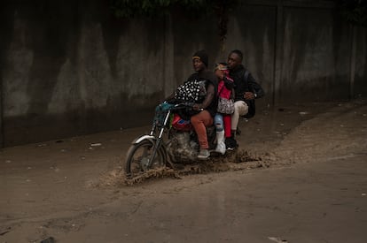  Una moto circula por una calle inundada. 