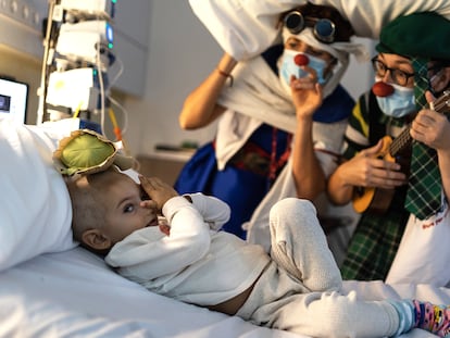 En la imagen, Luis Escuder, de dos años y medio, juega con unas payasas de la ONG Pallapupas en la habitación donde se encuentra hospitalizado en Barcelona.