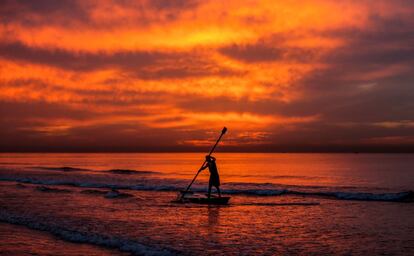 Un pescador palestino rema sobre su bote al atardecer frente a la costa de la ciudad de Gaza.