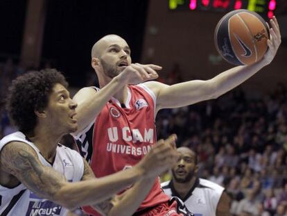 El escolta del UCAM Murcia Andr&eacute;s Miso lanza a canasta ante la presi&oacute;n del alero del Blusens Monbus Deron Washington. / Lavandeira (EFE)