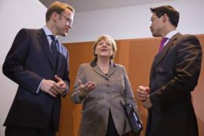 La canciller alemana Angela Merkel (centro), conversa con su ministro de Economía, Philipp Rösler (dcha) y el presidente del Bundesbank, Jens Weidmann (izda), a su llegada hoy al consejo de ministros en Berlín (Alemania).