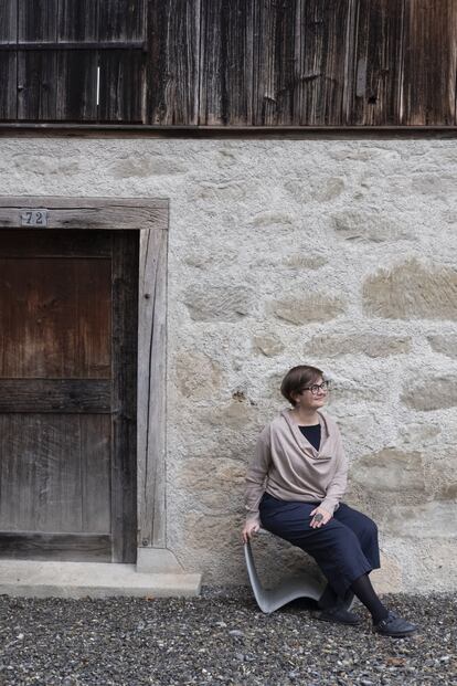 La joyera Gabi Veit, sentada frente a su estudio a las afueras de Zúrich.
<br><br>Veit se crio en Bolzano, en el norte de Italia, en una escuela que sus padres tenían en pleno campo. Luego estudió diseño gráfico en Innsbruck y terminó convirtiéndose en joyera en Florencia. Fue entonces cuando su gusto por lo imperfecto y lo cambiante la devolvió a buscar la inspiración en la naturaleza. Cerca de un bosque, Veit concluyó una reforma austera que hace convivir materiales nuevos —como el hormigón o la madera de pino— con la huella del edificio original.<br>