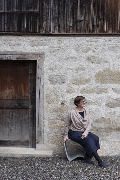 La joyera Gabi Veit, sentada frente a su estudio a las afueras de Zúrich.
<br><br>Veit se crio en Bolzano, en el norte de Italia, en una escuela que sus padres tenían en pleno campo. Luego estudió diseño gráfico en Innsbruck y terminó convirtiéndose en joyera en Florencia. Fue entonces cuando su gusto por lo imperfecto y lo cambiante la devolvió a buscar la inspiración en la naturaleza. Cerca de un bosque, Veit concluyó una reforma austera que hace convivir materiales nuevos —como el hormigón o la madera de pino— con la huella del edificio original.<br> 