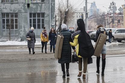 Tres músicos caminan por las calles de Novosibirsk tras un ensayo.