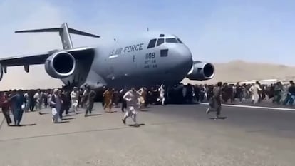 Captura de vídeo en la que se ve una multitud rodeando un avión militar de EE UU, este lunes en el aeropuerto de Kabul