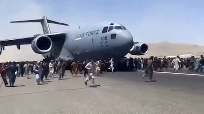 Captura de vídeo en la que se ve una multitud rodeando un avión militar de EE UU, este lunes en el aeropuerto de Kabul