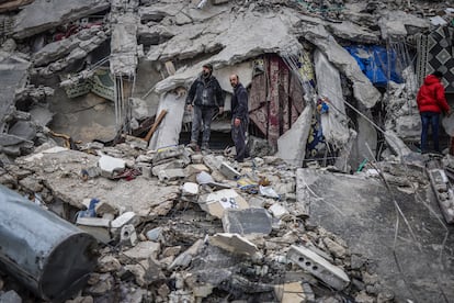  Syrian civilians and members of the White Helmets work to save people trapped beneath a destroyed building following a magnitude 7.8 earthquake that hit Syria.