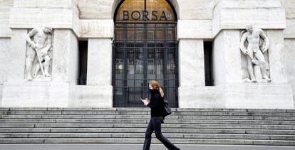 Una mujer pasa frente a la Bolsa de Milán.