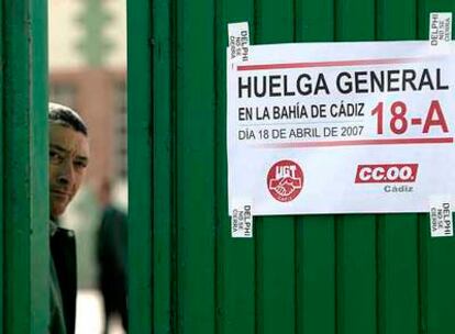 Un trabajador mira tras la puerta de una empresa de autobuses, durante la huelga en solidaridad con la plantilla de Delphi, ayer en Cádiz.
