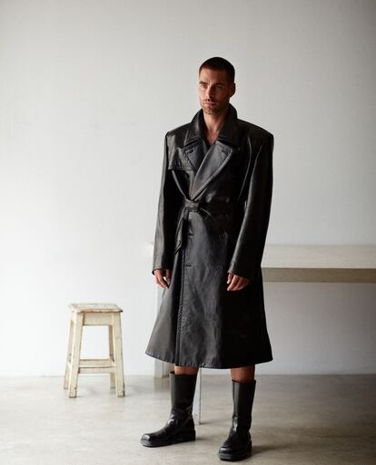 El modelo y actor posa con abrigo y botas Prada. 