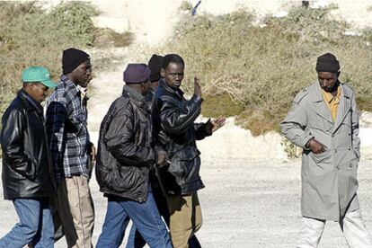 Varios inmigrantes caminan por Jaén mientras esperan ser contratados para recoger aceitunas.