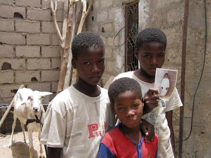 Tres de los hermanos Doua, fotografiados en su casa de Nuakchot. Los dos mayores, que sujetan la foto, vivieron esclavizados como jinetes de camellos.