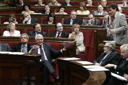 Maragall sonríe y gesticula durante la intervención de Artur Mas, de pie, ayer en el Parlamento catalán.