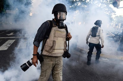 Un fotoperiodista trabaja con una máscara de gas puesta durante una manifestación en contra del Gobierno de Nicolás Maduro, en Caracas, el 26 de junio de 2017.