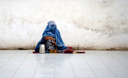 Una mujer afgana espera que alguien le lleve comida en Mazar-i-Sharif (Afganistán).