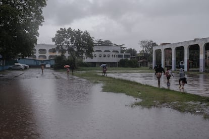 Bajo una fuerte lluvia, Priscila Santos lleva a sus hijas a la escuela en Baixa Sapateiro, una de las comunidades del Complexo da Maré.