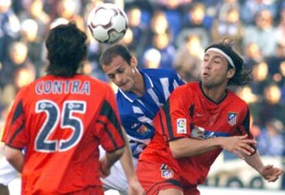 Pernía cabecea entre Contra y Jose Mari en el partido frente al Atlético, en el Colombino.