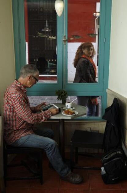 Un cliente de Azul de Fúcar ante una mesa con café y bizcocho casero.