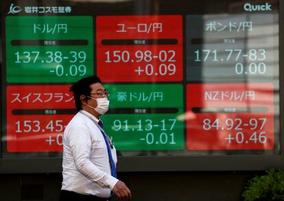 Un hombre camina junto a una pantalla que recoge la evolución del yen frente al dólar, en Tokio, el año pasado.