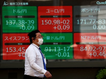 Un hombre camina junto a una pantalla que recoge la evolución del yen frente al dólar, en Tokio, el año pasado.