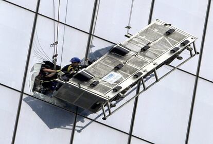 Finalmente, los bomberos rompieron el cristal más cercano al artefacto averiado y sacaron a los dos encargados de la limpieza exterior del edificio, que resultaron ilesos