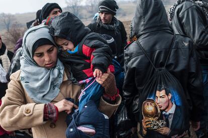 Un grupo de refugiados en un control de seguridad tras cruzar la frontera entre Macedonia y Serbia.