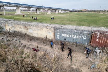 Migrants walk on the banks of the Rio Grande, February 27, 2024