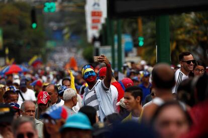 Un asistente a la concentración se toma una fotografía con su teléfono móvil.