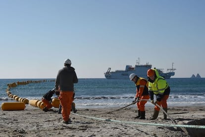 Un grupo de operarios trabaja en el enganche de un cable submarino de telecomunicaciones.