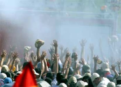 Los bomberos riegan con agua a los asistentes al evento católico.