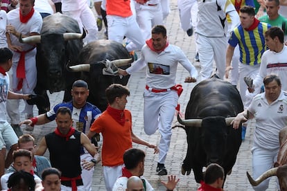 Un grupo de mozos corren junto a los toros de Miura en el tramo de la calle Telefónica.