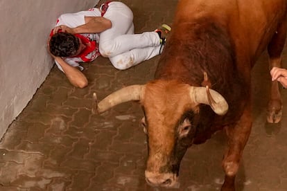 One of the waiters takes cover in the alleyway leading into the Pamplona bullring on Thursday. 
