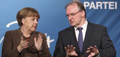 La canciller alemana, Angela Mekel (i), y el primer ministro de Sajonia Anhalt, Reiner Haseloof (d), durante un acto electoral del partido de la Uni&oacute;n Cristianodem&oacute;crata (CDU) en Halle, Alemania.