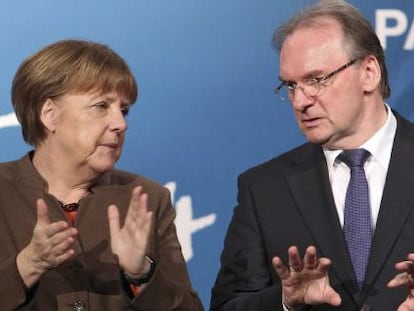 La canciller alemana, Angela Mekel (i), y el primer ministro de Sajonia Anhalt, Reiner Haseloof (d), durante un acto electoral del partido de la Uni&oacute;n Cristianodem&oacute;crata (CDU) en Halle, Alemania.
