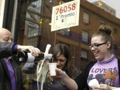 Trabajadores de la administración de lotería de la calle Gabriel Lobo, 7, en Madrid, celebran la venta de un décimo del 76058, agraciado con el premio gordo en el Sorteo Extraordinario de Navidad de este año. EFE/Archivo