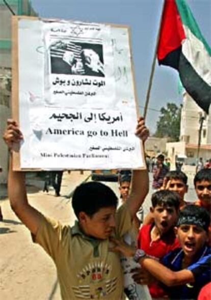 Un niño palestino levanta un cartel que dice: "América, vete al infierno".