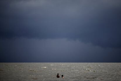 Una pareja nada en el océano cuando la tormenta tropical Gordon se acerca a Waveland, Misisipi.