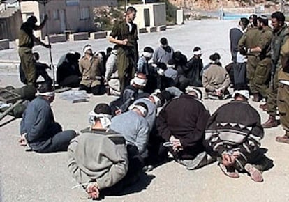 Prisioneros palestinos, con los ojos vendados y maniatados, en una plaza de Hebrón tras la incursión del Ejército israelí.