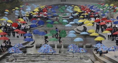 Numerosas personas visitan la instalación de paraguas de colores expuesta a lo largo del arroyo Cheonggye, en Seúl (Corea del sur), que simboliza el ambiente de la Tierra y la paz, el 27 de marzo 2014.
