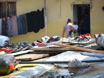 Los vecinos secan los zapatos y mantas, enlodados por las fuertes lluvias.