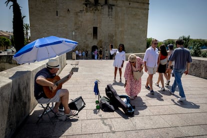 Un guitarrista, este domingo, en el Puente Romano de Córdoba.