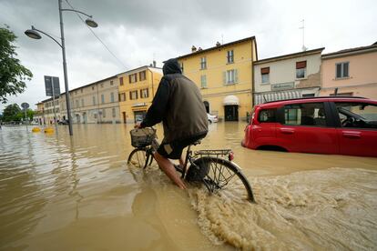 Un ciclista circula por una calle inundada de Castel Bolognese.