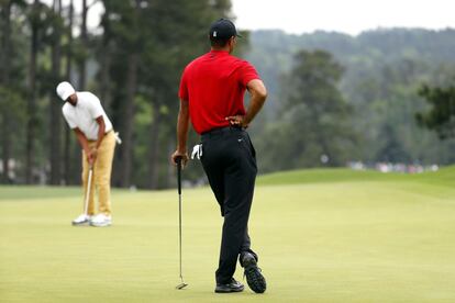 Woods observa a Tony Finau en el octavo green en la ronda final de los Masters de Augusta.