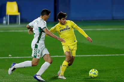 Gerard Moreno protege el balón ante el defensa del Elche Diego González este domingo en La Cerámica.