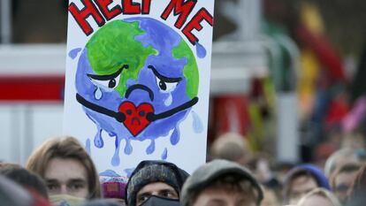 Manifestantes portan un cartel mientras asisten a una protesta durante la Conferencia de la ONU sobre Cambio Climático (COP26), en Glasgow, el 6 de noviembre de 2021.