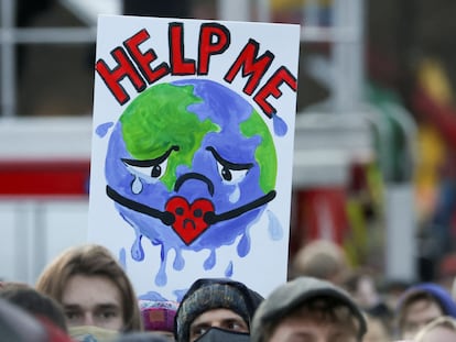 Manifestantes portan un cartel mientras asisten a una protesta durante la Conferencia de la ONU sobre Cambio Climático (COP26), en Glasgow, el 6 de noviembre de 2021.