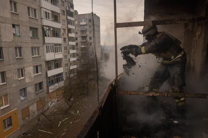Un bombero tiraba objetos desde el balcón de un apartamento mientras trabajaba para extinguir un incendio en un edificio residencial en Bajmut, el 12 de diciembre.