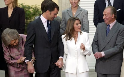 La reina Sofía mira los gemelos de zafiros y oro blanco regalo de Letizia Ortiz tras la petición de mano en un acto celebrado en el palacio del Pardo, Madrid, el 6 de noviembre de 2003. El heredero de la Corona, de 35 años, se comprometía con la periodista de TVE, de 31.