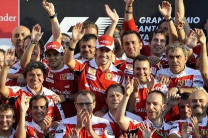 Alonso, en el centro, celebra su victoria en el Gran Premio de Italia junto al resto de componentes de la escudería Ferrari.
