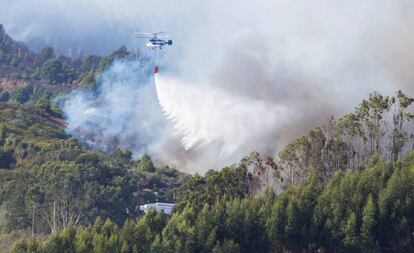 Un helicóptero realiza labores de extinción en la localidad de Guía.